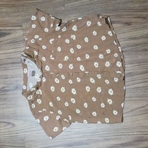 Flowy brown buttoned up shirt with white flowers and a collar.